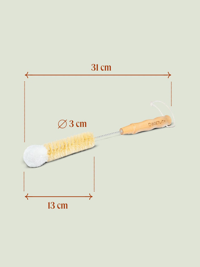 Nachhaltige Reinigungsbürste von Bidetlity mit Bambusgriff und Naturborsten, ideal zum Reinigen von Bidet-Flaschen. Die Bürste ist 31 cm lang, der Borstenkopf misst 13 cm in der Länge und hat einen Durchmesser von 3 cm.