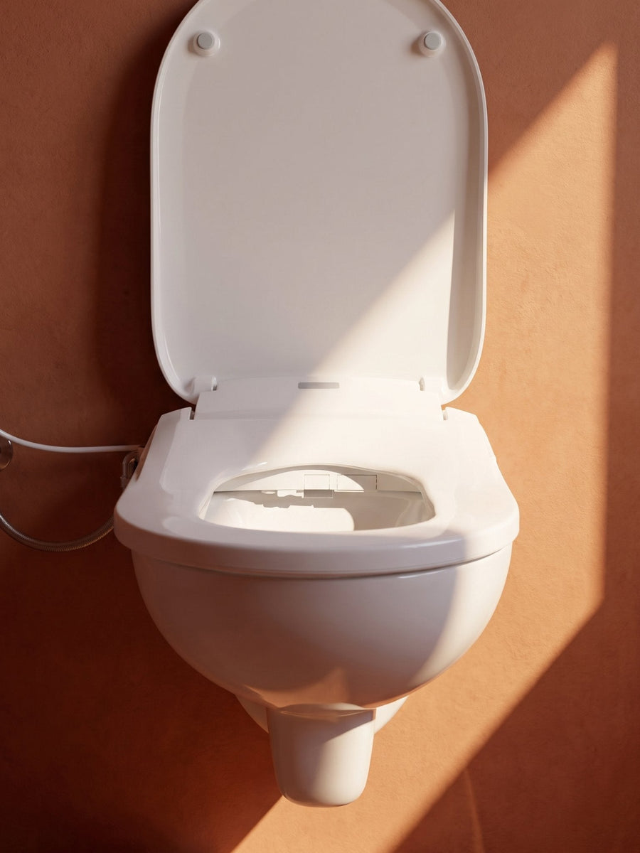 Bidetlity Deluxe Bidet-Sitz in einem warm beleuchteten Badezimmer