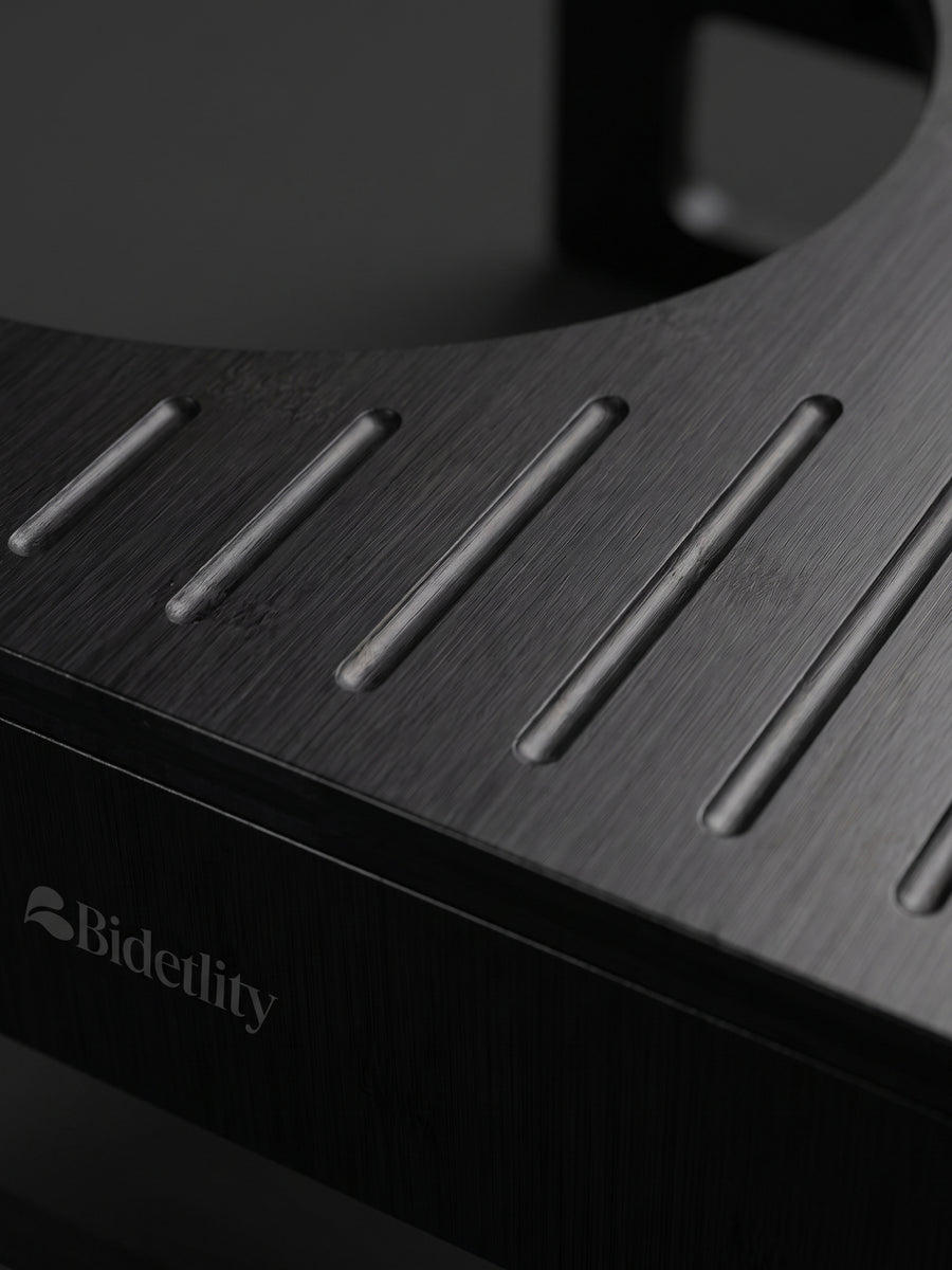 Kackhocker in All Black: Trittfläche mit Rillen und Bidetlity-Logo