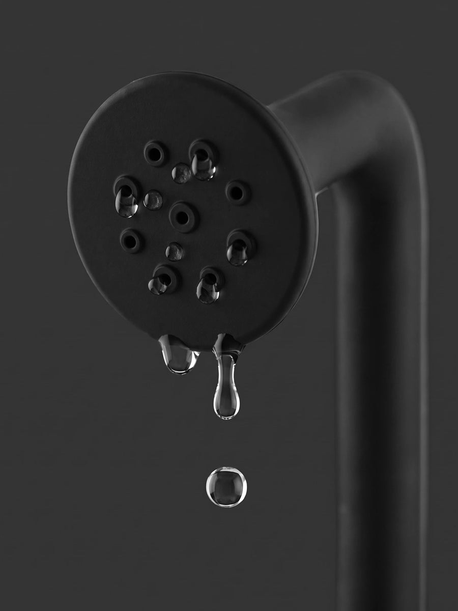 Schwarzer Duschkopf der Po-Dusche mit Wassertropfen